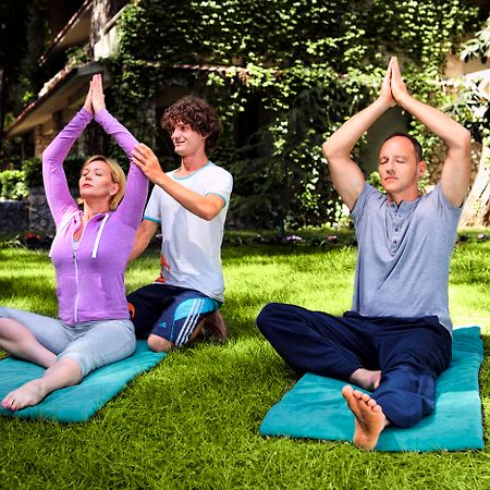 فندق مارتي ميرا تيكيروفا المظهر الخارجي الصورة A yoga teacher assists students with their practice.