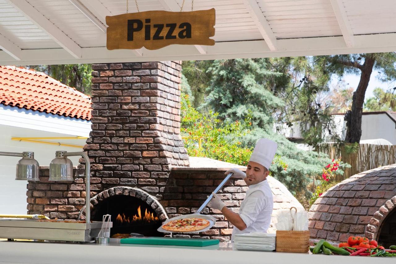 فندق مارتي ميرا تيكيروفا المظهر الخارجي الصورة Pizza being prepared in a wood-fired oven
